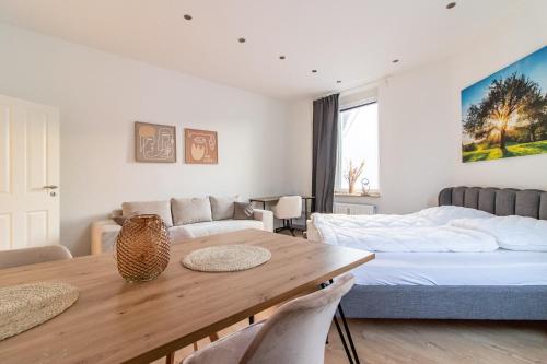 een woonkamer met een tafel en een bed bij Geräumige Wohnung mit 2 Schlafzimmern in Essen-Stadtwald Nähe Messe Essen in Essen