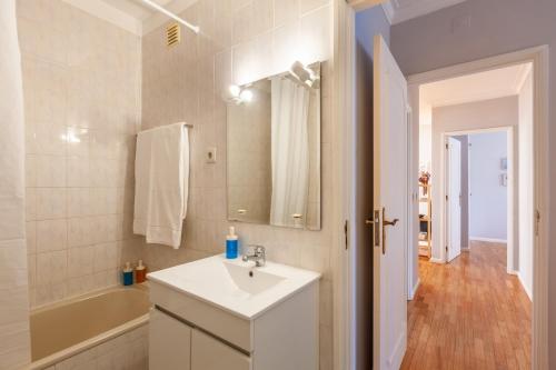 埃斯波森迪的住宿－Esposende Beach Apartment - Minho's Guest，一间带水槽、浴缸和镜子的浴室