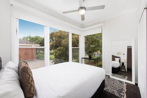 a bedroom with a white bed and a large window at Bancroft House on Scenic Mudgee Golf Course in Mudgee