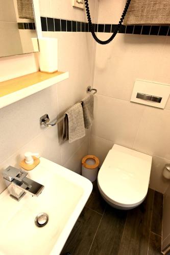 a bathroom with a white toilet and a sink at Bel-Art in Hvar