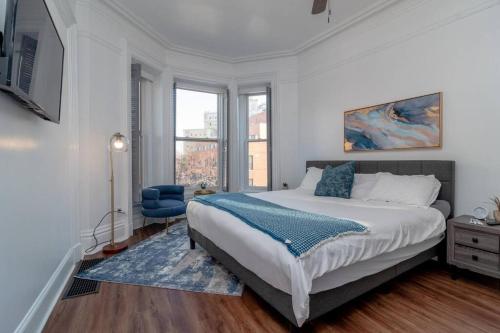 um quarto com uma cama grande e uma cadeira azul em Historical 5 Bedroom Villa that sleeps 12 guests with Patio, Fireplace, Grill and FREE parking em Chicago