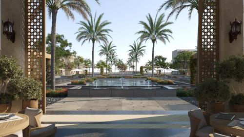 a courtyard with a fountain and palm trees at Jaz Sakhra in Marsa Matruh