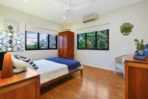 1 dormitorio con 1 cama y 2 ventanas en Parap Estate Pool Paradise from the Top-floor en Parap