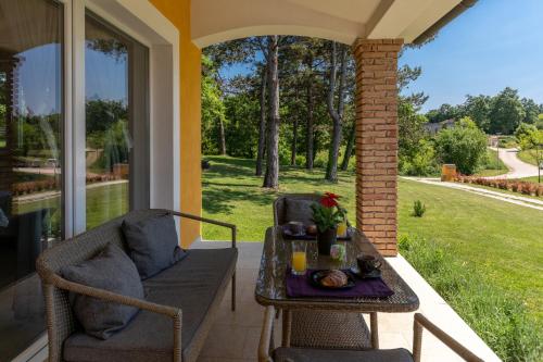 um alpendre com uma mesa, uma cadeira e uma janela em Villa Kristina em Pazin