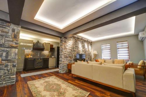 a living room with a couch and a stone fireplace at Kerem ile Aslı Butik Hotel in Melikgazi
