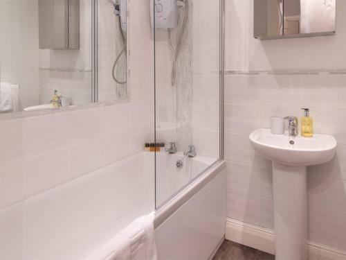a white bathroom with a shower and a sink at 1 Bed in Harrogate HH080 in Harrogate
