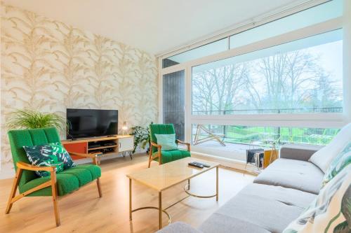 un salon avec un canapé, des chaises et une télévision dans l'établissement Tourcoing - Nice apartment for 4 parking, à Tourcoing