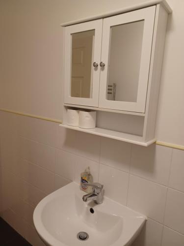 a bathroom with a sink and a cabinet at Q Flat Skyview Central Bradford in Bradford