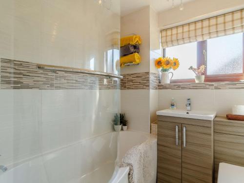 La salle de bains blanche est pourvue d'une baignoire et d'un lavabo. dans l'établissement 3 Bed in Dereham 87159, à East Dereham