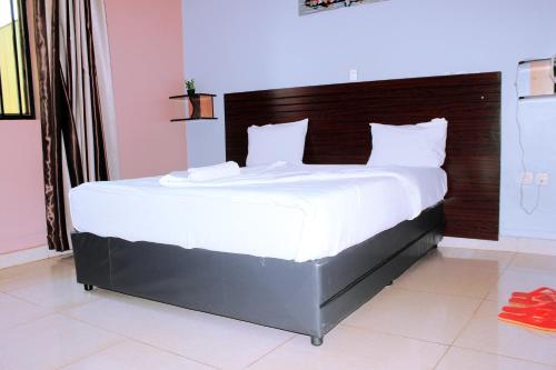 a large bed in a bedroom with red shoes on the floor at REBERO RESORT Ltd in Kigali