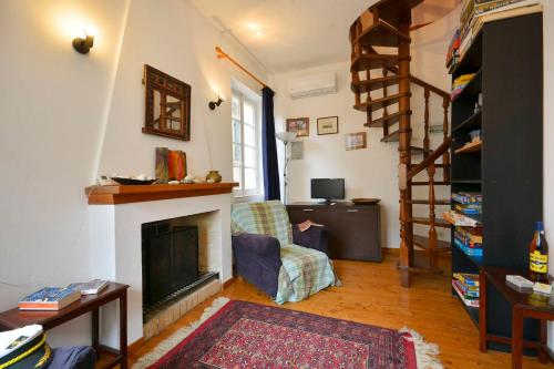 a living room with a fireplace and a stair case at Iliokambida house in Corfu
