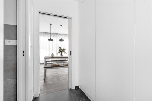a hallway with a door leading to a kitchen with a table at Roubenka "Tam kde lišky dávají dobrou noc" in Cerny Dul