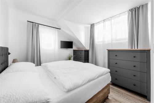 a white bedroom with a bed and a dresser and a window at Roubenka "Tam kde lišky dávají dobrou noc" in Černý Dŭl