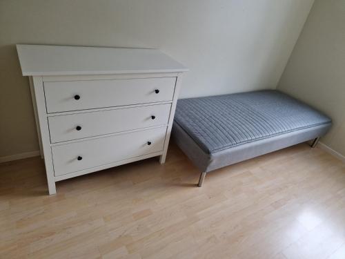 a bedroom with a bed and a white dresser at God søvn in Lillestrøm