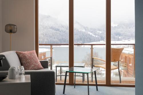 a living room with a couch and a glass table at Appartementhotel am Weissensee in Weissensee