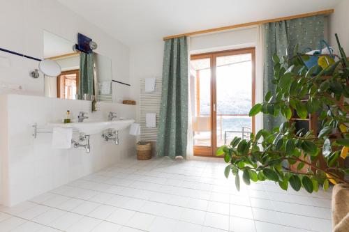 a bathroom with a sink and a large window at Appartementhotel am Weissensee in Weissensee