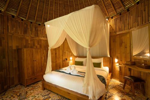 a bedroom with a bed with a canopy at Ubud Art Resort in Ubud
