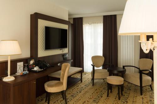 a hotel room with a desk and chairs and a television at Hotel Schopenhauer Hof in Frankfurt/Main