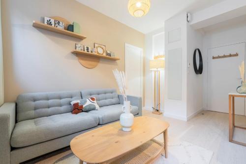 un salon avec un canapé bleu et une table dans l'établissement Renovated 1 bedroom apartment, à Lille