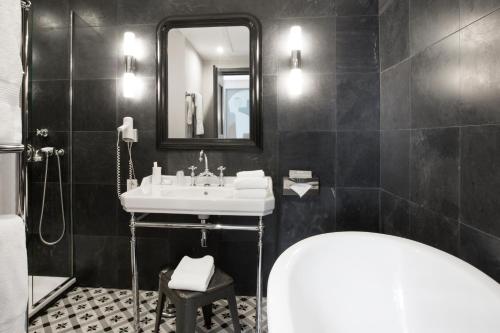 a bathroom with a sink and a mirror and a tub at Auberge de Banne in Banne