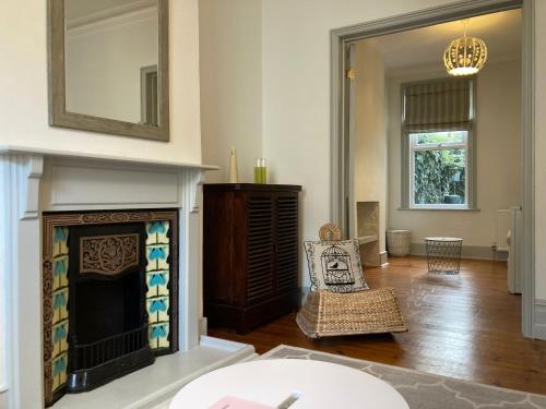a living room with a fireplace and a mirror at The Blue House in Worthing