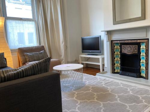 a living room with a couch and a fireplace at The Blue House in Worthing