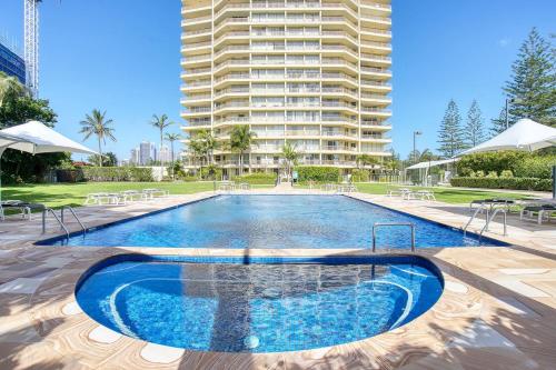 a large swimming pool with a large building in the background at Retro Main Beach Hidden Gem with Waterfront Views in Gold Coast