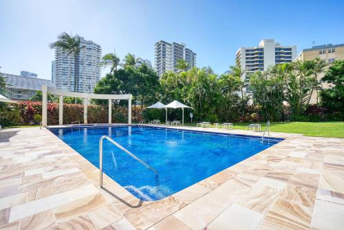 a swimming pool with blue water and some buildings at Retro Main Beach Hidden Gem with Waterfront Views in Gold Coast