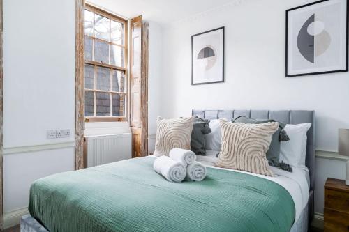 - une chambre avec un lit et des serviettes dans l'établissement Vauxhall - 2BR with Patio - CityApartmentStay, à Londres
