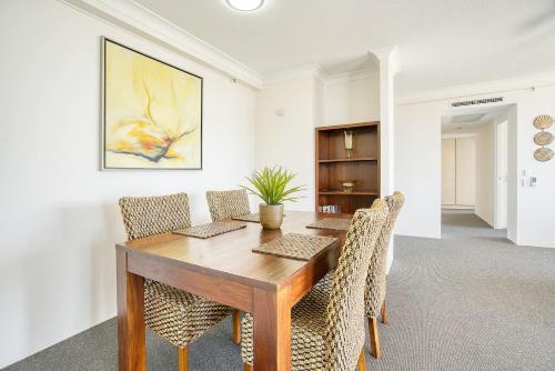 a dining room with a wooden table and chairs at Retro Main Beach Hidden Gem with Waterfront Views in Gold Coast