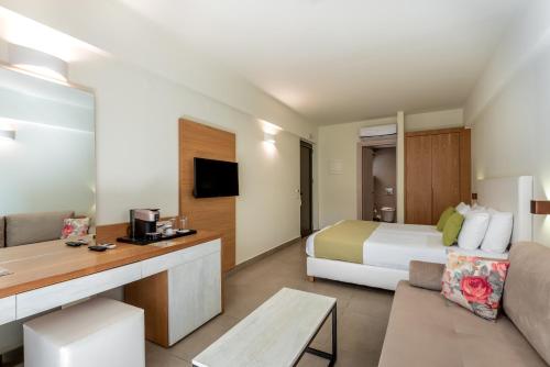 a hotel room with a bed and a couch at Airis Boutique Hotel & Suites - For adults only in Kato Daratso