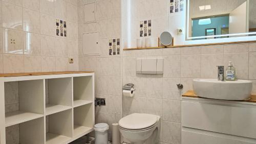 La salle de bains est pourvue de toilettes, d'un lavabo et d'un miroir. dans l'établissement Ferienwohnung Meerzeit, à Kühlungsborn