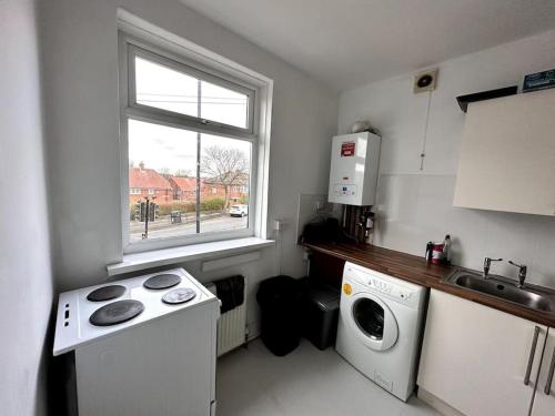 a kitchen with a washing machine and a window at 1 Bedroom flat, Close to All You Need! in Kenton