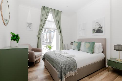 a bedroom with a bed and a window at Stylish Apartments - Hyde Park in London