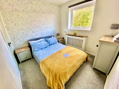 a small bedroom with a bed and a window at Leominster 3 Bedroom House, Private Parking and Garden in Leominster