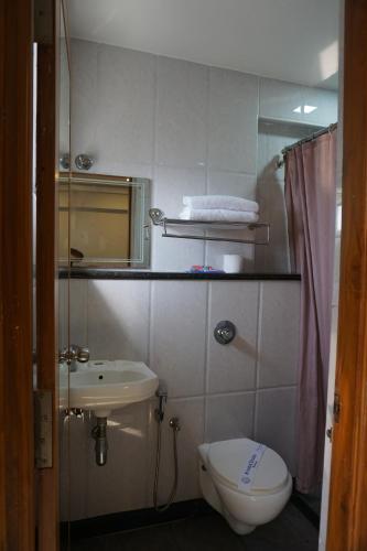 a small bathroom with a toilet and a sink at Kingscross Residency in Chennai