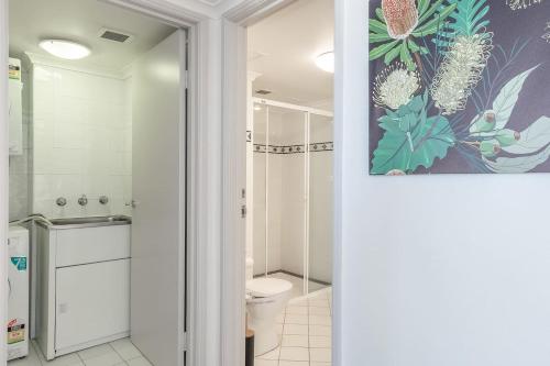 une salle de bain avec toilettes et un tableau au mur dans l'établissement Top of the Town with Sydney CBD at its Doorstep, à Sydney