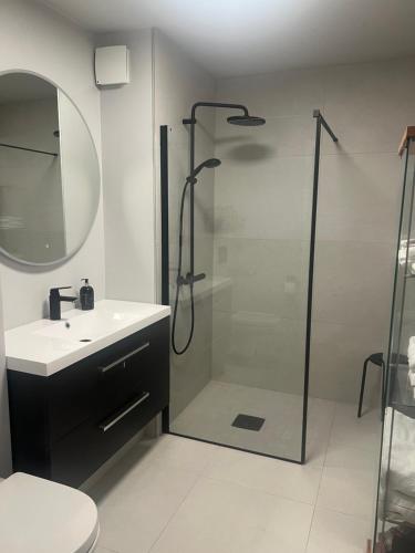 a bathroom with a shower and a sink and a mirror at Huseby - Perfect for World Cup Trondheim 2025 in Trondheim