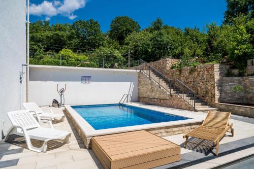 uma piscina com duas cadeiras e uma mesa em Mata Family Apartments em Molunat