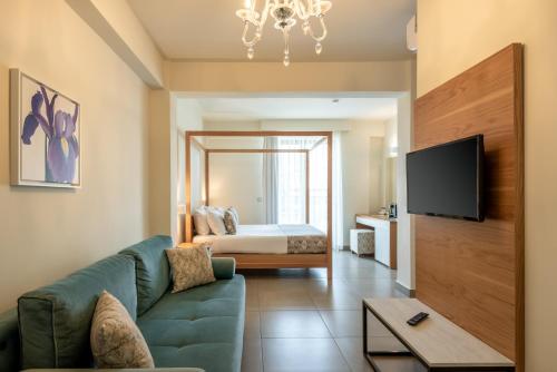 a living room with a couch and a bed at Airis Boutique Hotel & Suites - For adults only in Kato Daratso