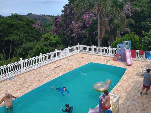 un groupe de personnes jouant dans une piscine dans l'établissement Chácara Nossa Senhora Aparecida, à Ribeirão Pires