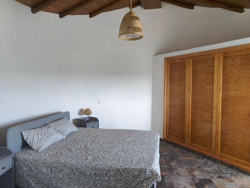 - une chambre avec un lit et un placard en bois dans l'établissement Quinta da Eira Silves, à Silves