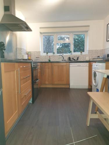 a large kitchen with wooden cabinets and a sink at Mulberry House Excellent central location Courtyard garden 3 Bedrooms sleeps up to 6 Parking in Exeter