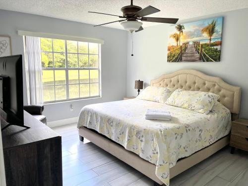 Un dormitorio con una cama y un ventilador de techo. en Great Lovely Family Apartment close Disney, en Kissimmee