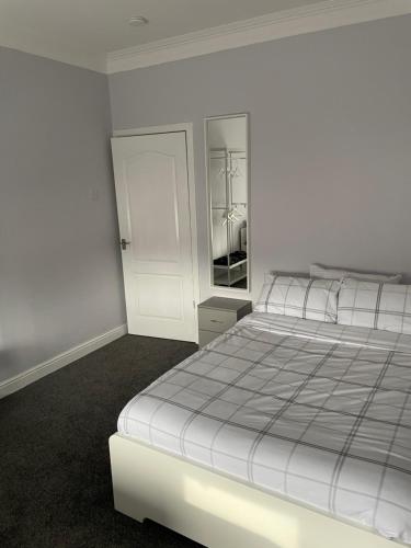 a white bedroom with a bed and a closet at Bellshill , Belvidere central upper apartment in Bellshill