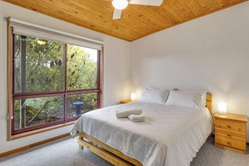 een slaapkamer met een bed en een groot raam bij Doesntmatta - Beachside Breeze at St Andrews Beach in Saint Andrews Beach