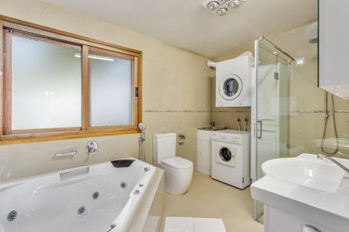 een badkamer met een bad, een toilet en een wastafel bij Doesntmatta - Beachside Breeze at St Andrews Beach in Saint Andrews Beach