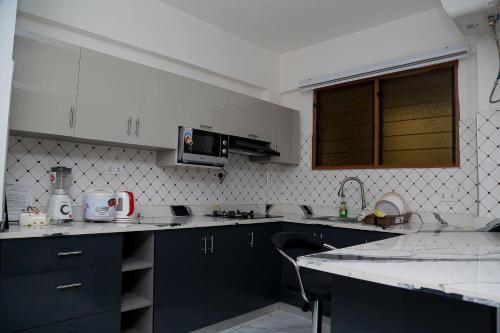 uma cozinha com armários azuis e um lavatório em BELLEHAVEN LUXURY APARTMENT em Acra