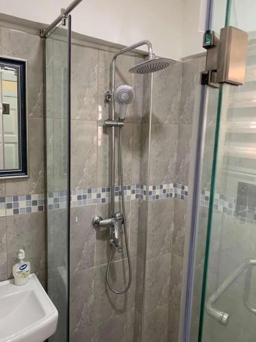 um chuveiro com uma porta de vidro ao lado de um lavatório em BELLEHAVEN LUXURY APARTMENT em Acra