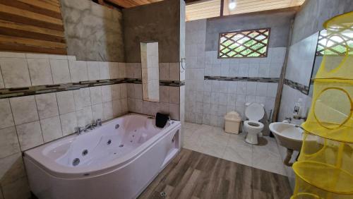 a bathroom with a tub and a sink and a toilet at Playa Tortuga in Puerto Misahuallí